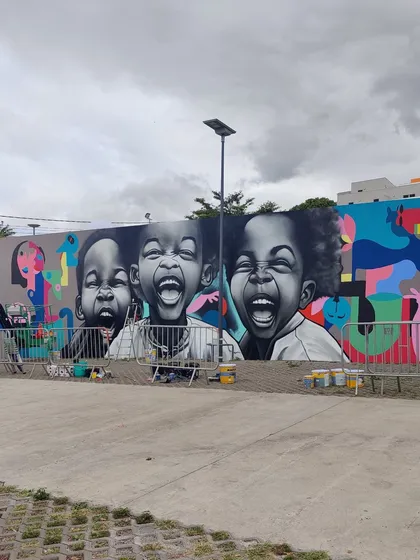 The mural in context with other artworks at the festival, showing a blend of our abstract style with hyperrealism.