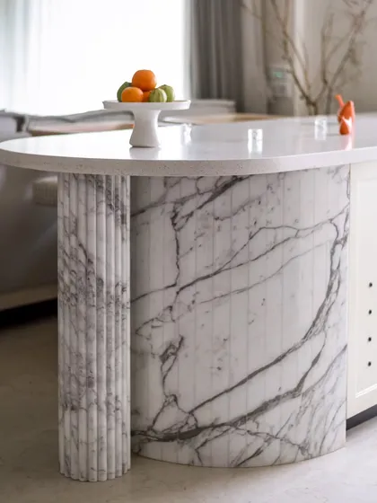 This half-round serving counter, crafted entirely from marble, is a statement of luxury. The extended countertop is supported by a beautifully carved fluted column, making it a true visual centerpiece.