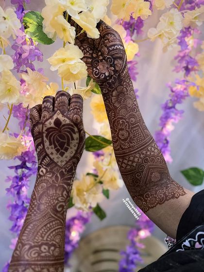 A stunning lotus design on the back of the hand, set against a backdrop of flowers. The lotus is a central element in many of my traditional designs.