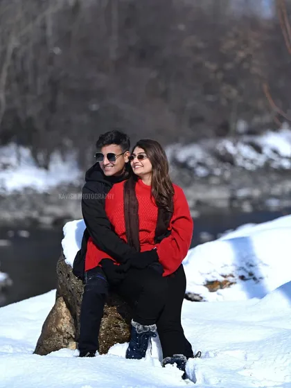 A candid shot of the couple sharing a laugh in a snowy setting, capturing a genuine moment of joy during their pre-wedding session.