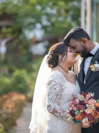 A tender moment between the bride and groom, framed by the beautiful garden scenery. The soft light and their close embrace make this a very romantic wedding portrait.