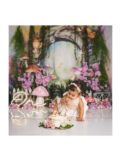 A magical moment from an enchanted forest cake smash. This little fairy is curiously poking her first birthday cake.