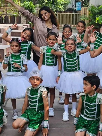 The Kids Jazz batch posing with their instructor, Arushi. This picture captures the fun and excitement of recital day, with students in their green and white costumes, ready to perform.