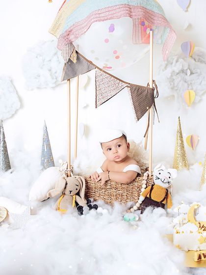 Up, up, and away. Our little traveler is ready for an adventure in his hot air balloon during this creative six-month milestone session.