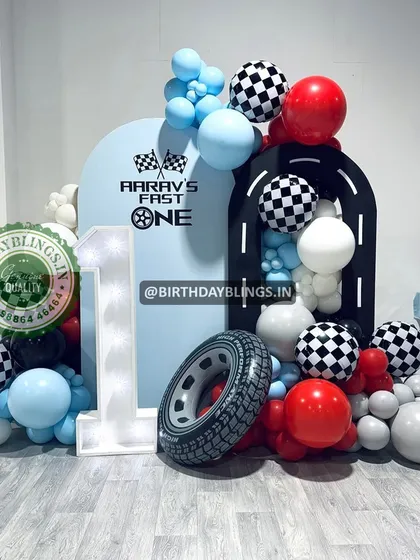 A "Fast One" theme with a different color scheme, using red, light blue, and white. The light-up number '1' and tire prop are key elements.