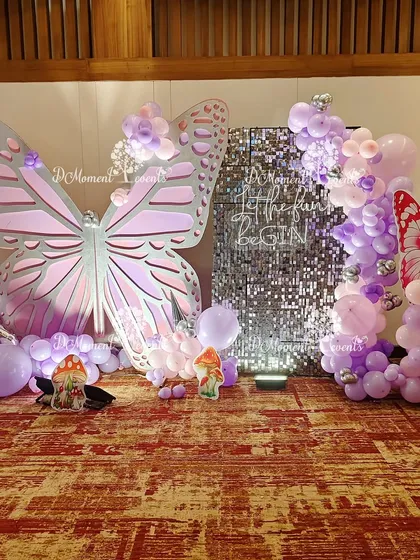 A complete view of the butterfly photo booth, featuring a large pink butterfly, a sparkling sequin panel, and a smaller red butterfly on a balloon pillar, offering varied photo opportunities.