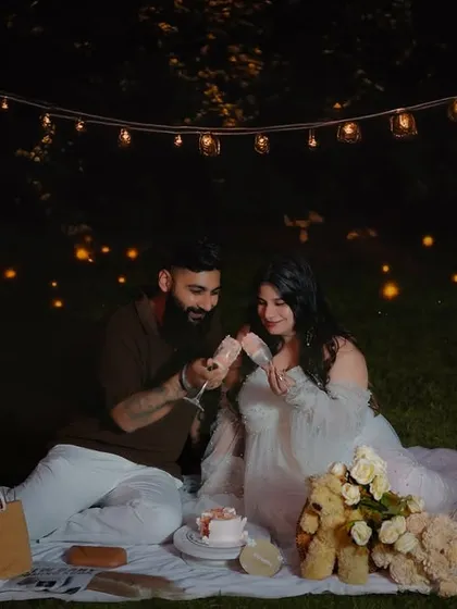 A romantic outdoor maternity picnic under a canopy of twinkling lights. This evening session creates a magical and intimate atmosphere, perfect for celebrating the journey to parenthood.