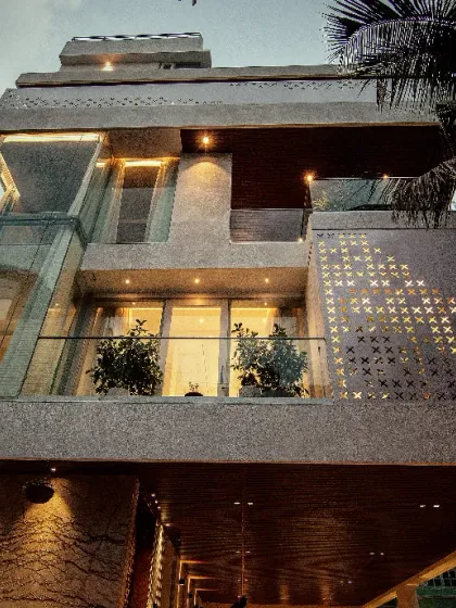 This building's facade features a striking perforated screen with a cross pattern, which creates interesting light play on the balconies while providing privacy for the residents.