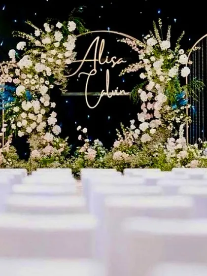 We designed this elegant stage for a nighttime engagement, using midnight blue as our canvas. The golden arches, white floral arrangements, and custom neon signage created a magical and intimate setting.