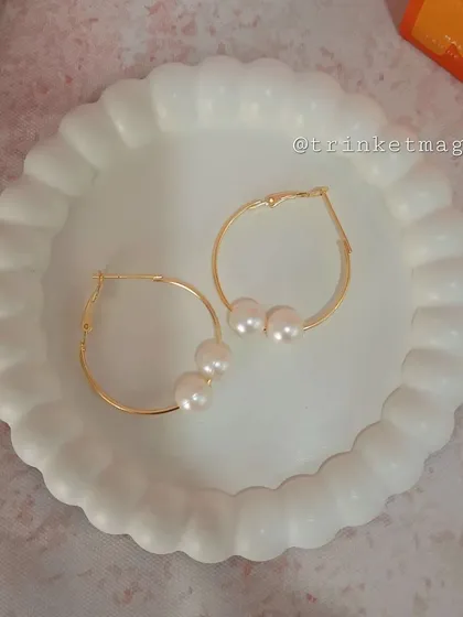 Classic and elegant, these simple gold hoop earrings are adorned with three delicate pearls. They are a timeless accessory for any occasion.