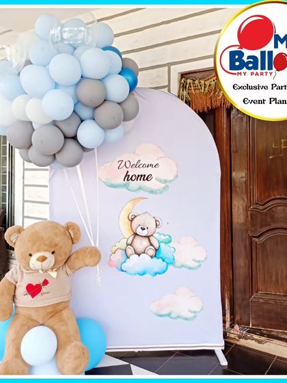 A "Welcome Home" party with a teddy bear theme. The simple and sweet setup includes a large teddy bear, a custom backdrop, and a cluster of balloons.