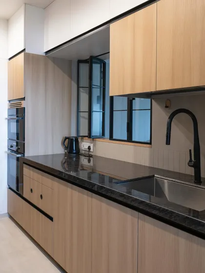 A wider view of the same parallel kitchen, showing the tall unit with built-in ovens. This vertical arrangement is a great space-saving strategy in compact kitchens.