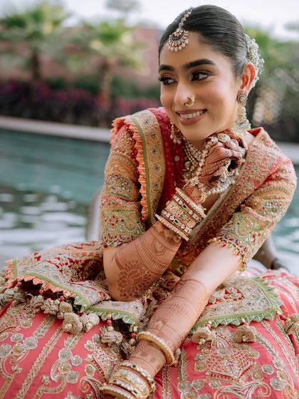 A close-up showcasing the intricate details of the bride's henna, jewelry, and stunning lehenga. Every element comes together to create the perfect bridal look.
