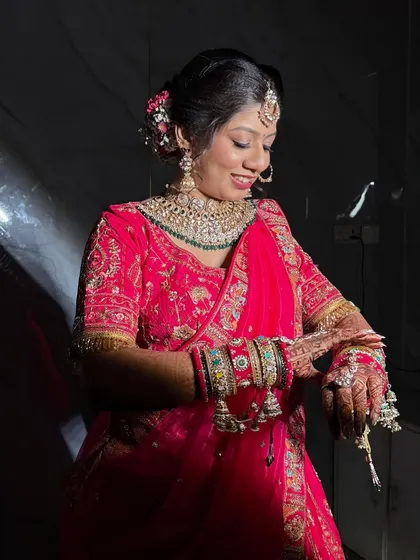 This candid shot captures the bride admiring her intricate henna and jewelry. The makeup on her face is in perfect harmony with the traditional elements of her look, from the floral bun to the kalire.