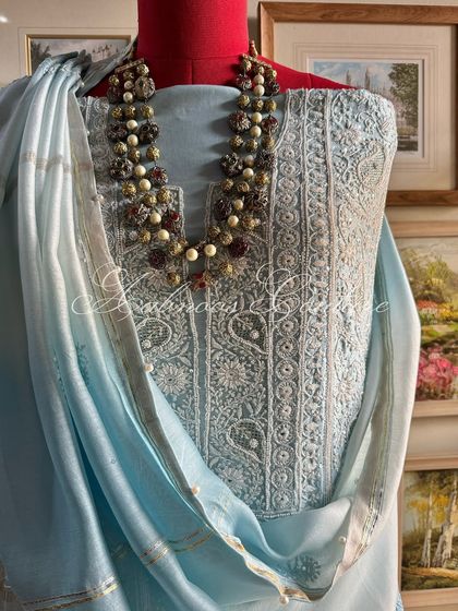 A three-quarter view of the suit, styled with a necklace to show its versatility for formal events.