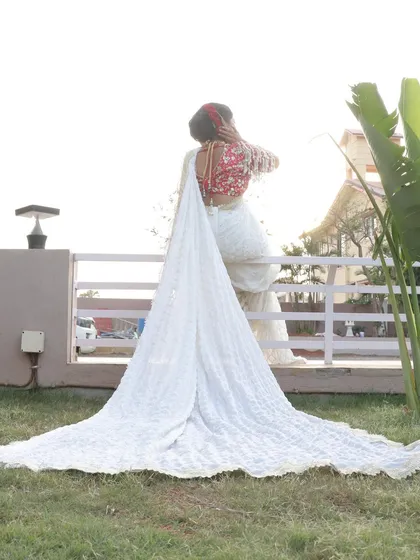 The dramatic trail of a custom bridal saree creates a breathtaking silhouette. This shot highlights how the right styling, paired with perfect makeup, can create unforgettable wedding photos.