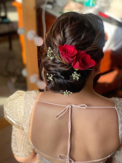 Here's a soft textured bun for the bride's mom, adorned with beautiful red roses. It's an elegant and age-appropriate style that still feels modern and special.