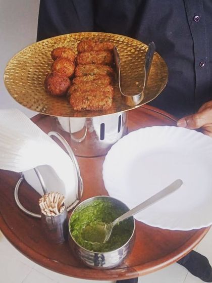 A tray of assorted vegetarian snacks, including kebabs and cheese balls, for a Hawan ceremony.
