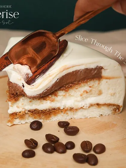 Slice through the shine. This image captures the moment of cutting into my Tiramisu entremet, revealing the magic within.
