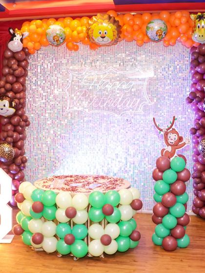 Another angle of the jungle theme decor, showing the full balloon arch over the sequin backdrop and the lit-up "3" marquee number, perfect for milestone birthdays.