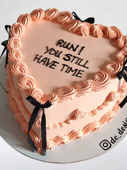 A humorous heart-shaped cake for an engagement party with the message "Run! You still have time." It's a fun and cheeky cake for a couple with a great sense of humor.