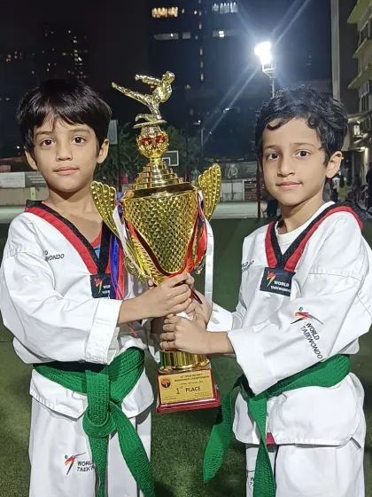 Two brothers, both green belts, celebrating their victory together. Training with family makes the journey even more special.