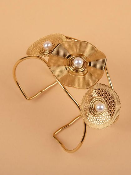 An angled shot of the gold floral cuff bracelet.