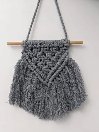 A sample of our new macrame work, this small, grey wall hanging brings a touch of boho texture to any room. It's a great way to fill a small space with handmade art.