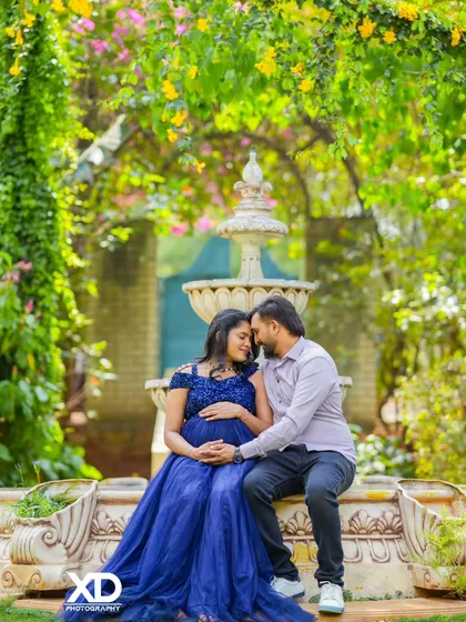 An intimate portrait of a couple by a fountain, their heads close together, sharing a quiet moment.
