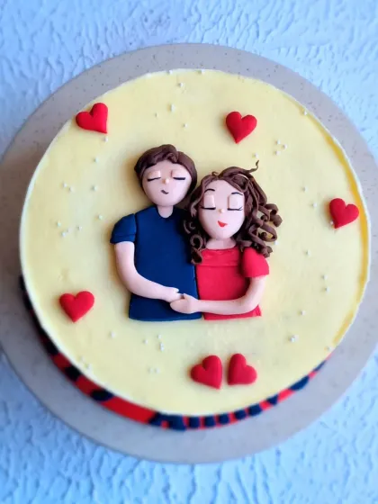 A sweet anniversary cake topped with a hand-sculpted fondant couple. Learning to create simple, cute figurines like this is a great way to personalize any cake.
