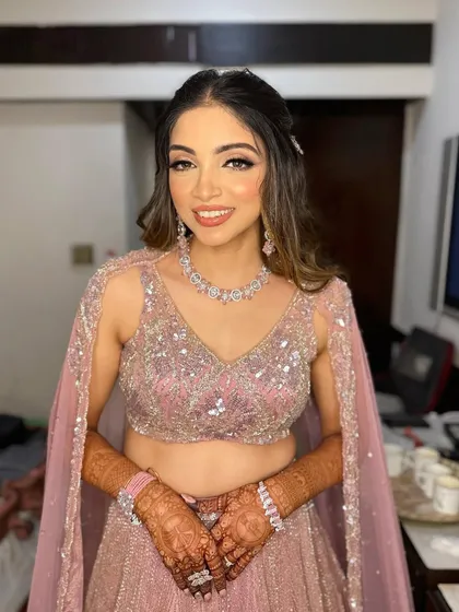 A beautiful soft glam look for Hetal's Sangeet. The makeup features a defined eye and a peachy nude lip to complement her pink lehenga.