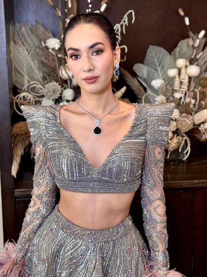 A direct portrait of the high-fashion look, showcasing the structured, embellished top and flawless makeup.