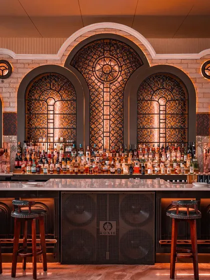 My bar, fully stocked and ready for the night. The intricate window designs and warm lighting make it the dramatic centerpiece of the mansion.