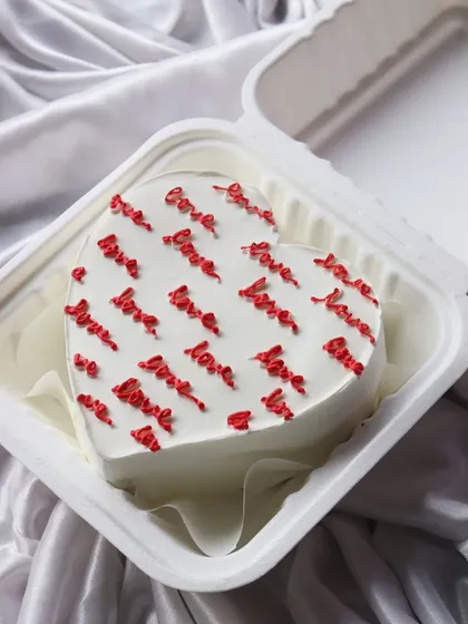 This heart-shaped bento cake is covered in the word 'love' and is perfect for anniversaries or Valentine's Day.