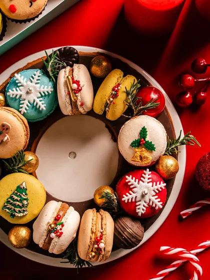 A close-up of the macaron wreath, showcasing the detailed decorations on each macaron, from snowflakes to Christmas trees. It's a testament to the artistry and festive flavor I bring to my holiday collection.