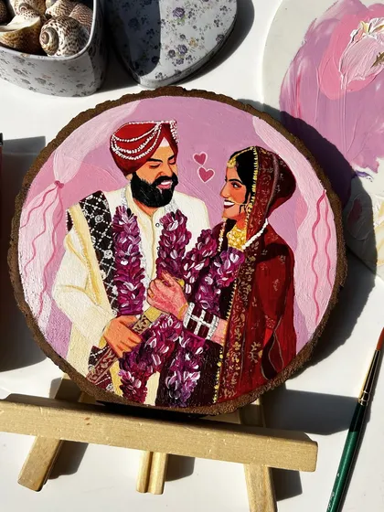 A vibrant wedding portrait capturing the joy of a Sikh couple. The details of their traditional attire and the garlands are carefully hand-painted against a soft pink backdrop.