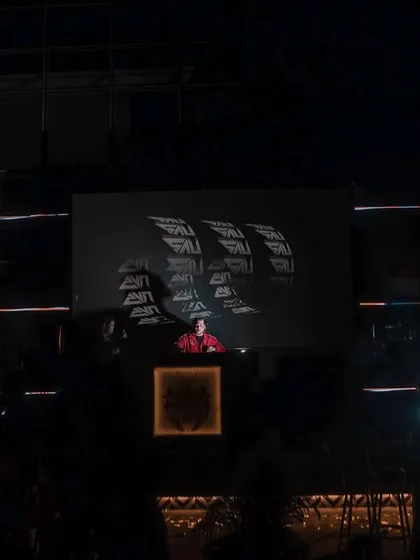 A wide shot showing me on a massive stage at House of Lords, with my logo on the big screen. I'm comfortable playing on any scale.