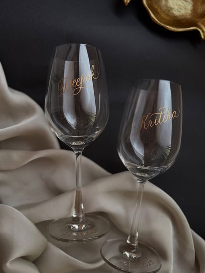 A pair of wine glasses engraved with names, perfect for an anniversary, wedding, or just a special occasion.