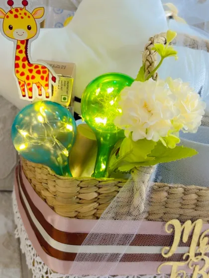 A close-up of the charming details in the parent-to-be hamper, including a giraffe sticker and fairy lights for a magical glow.
