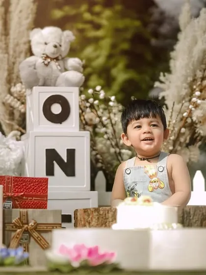 A big smile from the birthday boy. His excitement is palpable in this outdoor first birthday shoot, filled with classic toys and decorations.