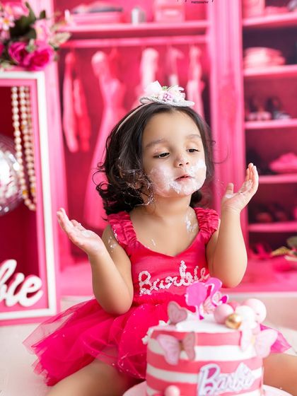 "Is this all for me?" The wonder and excitement of a cake smash are written all over her face in this adorable Barbie-themed shot.
