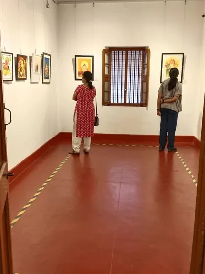 The gallery space at the Indian Institute of World Culture, with visitors appreciating the Ganesha paintings on display.