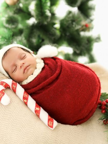 The sweetest Christmas present. This little one is sleeping so soundly, nestled in a red wrap with a tiny candy cane. A perfect newborn holiday portrait.