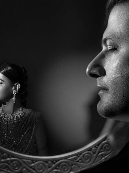 A close-up of the mirror reflection concept. This tight crop focuses on the contrast between his profile and her reflection, creating an intimate and artistic pre-wedding photograph.