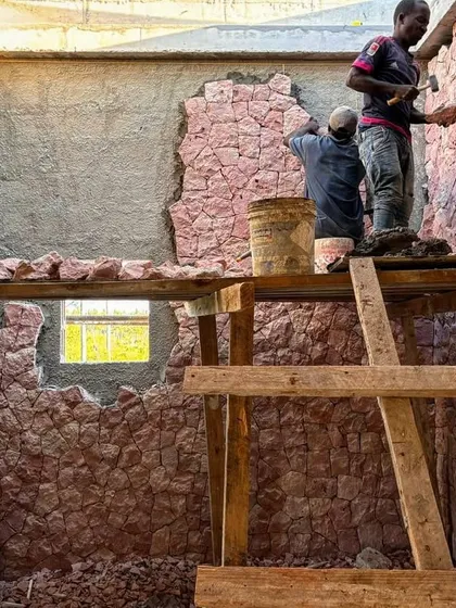 The interior of a bathroom at Kizikula takes shape with hand-applied coral stone walls. We often leave parts of the material exposed, creating a raw, textured surface that feels connected to the natural environment.