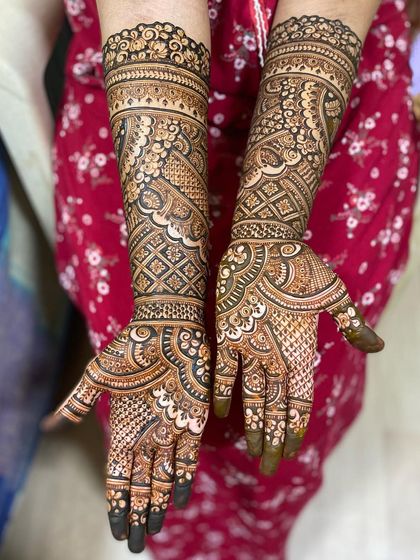 This full bridal design is a beautiful example of symmetry and detail, with matching patterns on both hands and arms.