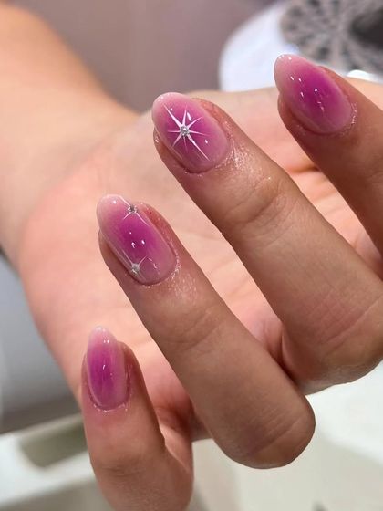 A close-up of the gradient pink nails, highlighting the clean ombre and the sharp, sparkling star design.