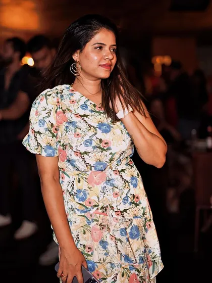 A guest in a floral dress, adding to the vibrant atmosphere of the party.
