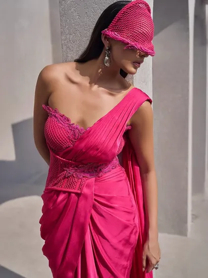 This hot pink corset sari is a statement of power and passion. Drenched in a vivid hue, it is cinched to perfection and draped with boldness.