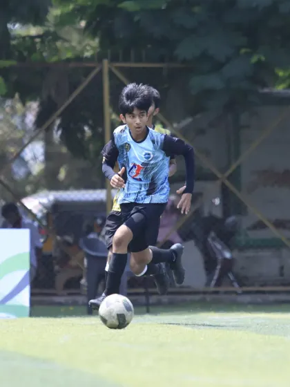 A young attacker running with the ball, focused on creating a chance. This image captures the speed and agility of our players.